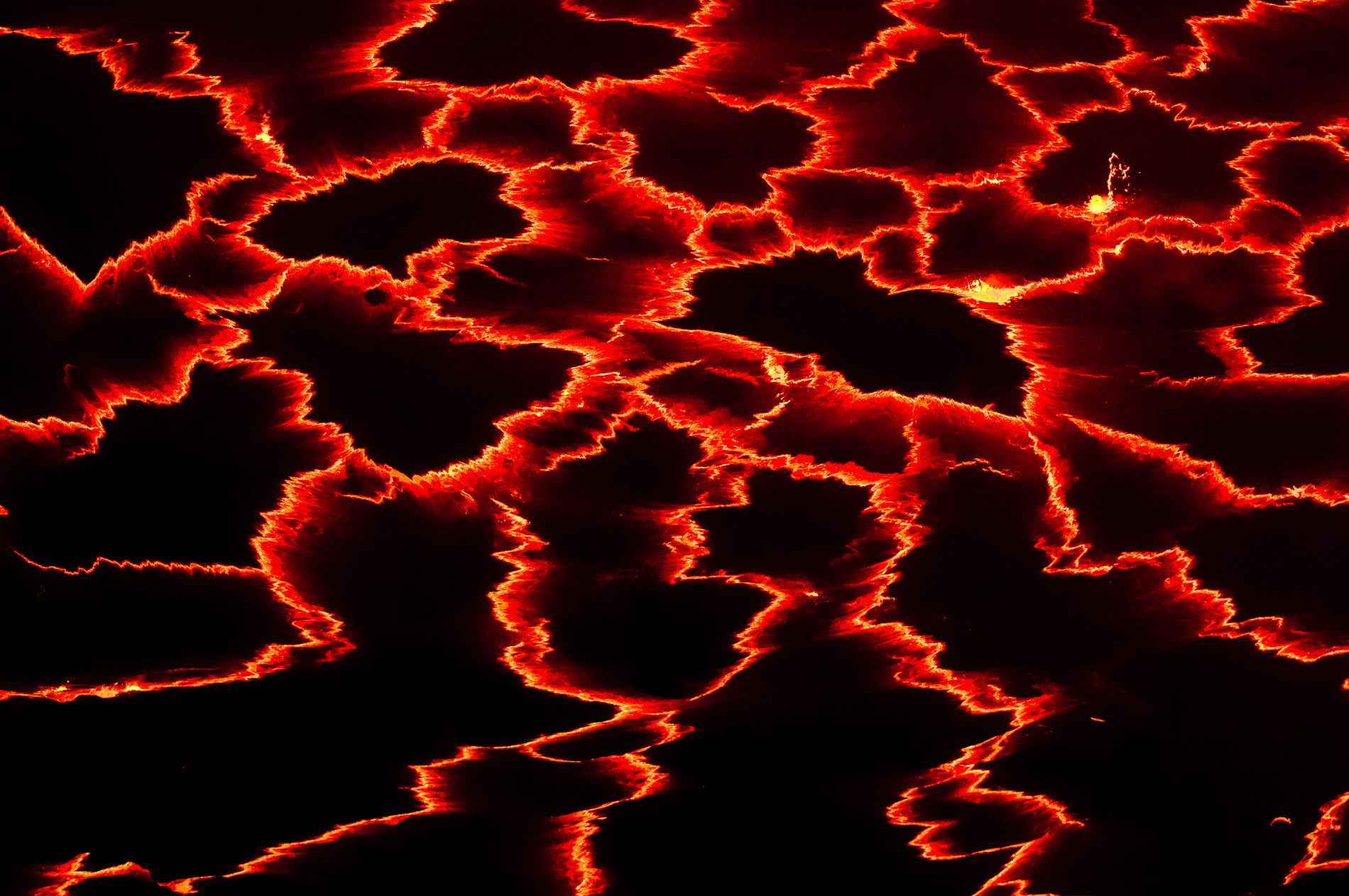 The lava lake is in permanent motion. At night the lava crust tears and dramatic stripes take shape according to the movements of the molten lava. Congo.